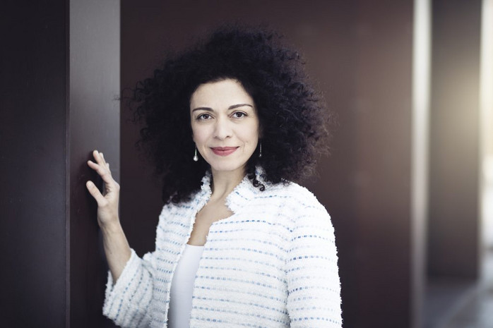 Marianna Shirinyan med hånden på en søjle foran mørke søjler